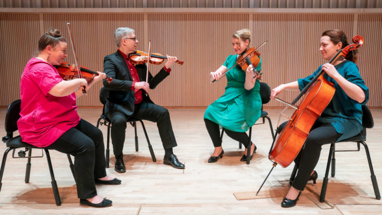 Four violinist and one sellist playing together.